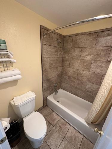 梅德福Relax Inn of Medford的浴室配有卫生间、浴缸和卫生间。
