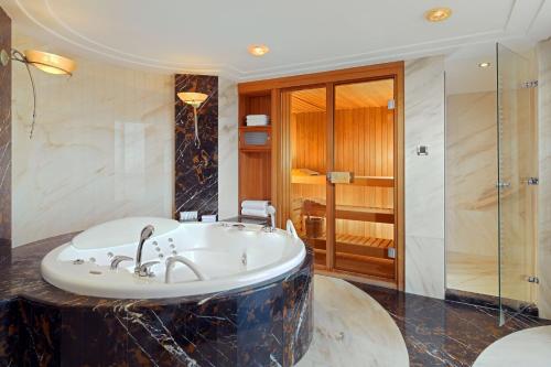 萨格勒布威斯汀泽格布酒店的设有带浴缸和淋浴的浴室。