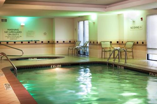格雷普韦恩达拉斯机场北/格雷普韦恩春季山丘套房酒店的一个带桌椅的健身房内的游泳池
