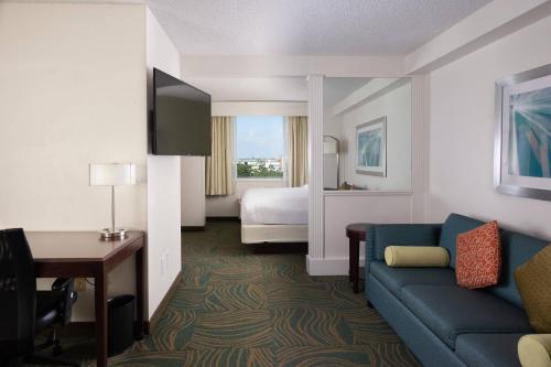达尼亚滩劳德代尔堡机场春季山丘套房酒店的酒店客房设有一张沙发和一张床