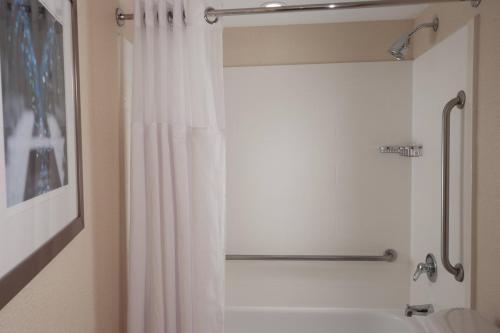 达尼亚滩劳德代尔堡机场春季山丘套房酒店的一间带白色淋浴帘的浴室