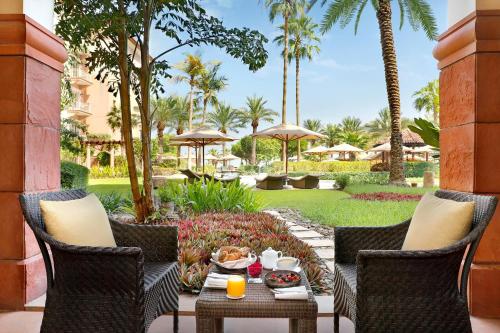 迪拜迪拜丽思卡尔顿酒店的庭院配有椅子和桌子,上面有食物