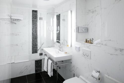 蒙特勒Grand Hotel Suisse Majestic, Autograph Collection的白色的浴室设有水槽和卫生间。