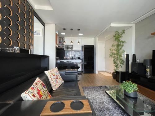 坎皮纳斯Studio Deluxe - Dot 173的客厅配有黑色沙发和桌子