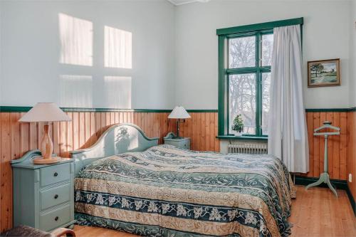尤城Piece of Hjo Vandrarhem的一间卧室配有一张床、两盏灯和一个窗户。