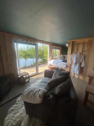 罗斯奈格尔Secluded Lakeside Off Grid Cabin with Outdoor Bath的客厅配有沙发和1张床