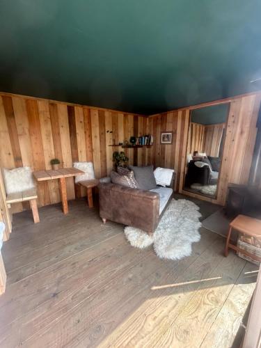 罗斯奈格尔Secluded Lakeside Off Grid Cabin with Outdoor Bath的客厅配有沙发和桌子