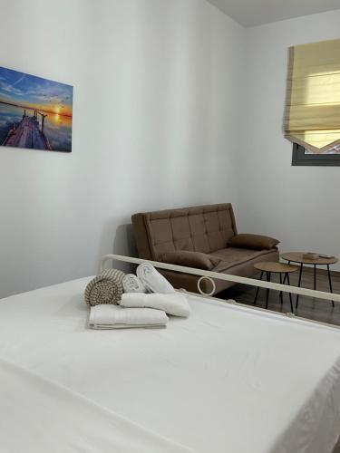 斯巴达Paola’s apartments near Athens Airport的客厅配有沙发和毛巾,位于地板上