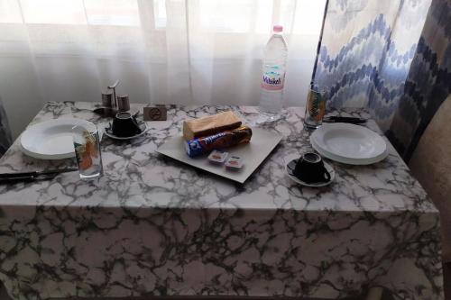 卡尔季察Κεντρικό στούντιο στην Καρδίτσα.的一张桌子,上面放两个盘子和一瓶水