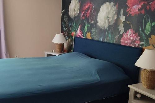 塞里尼昂-迪孔塔Mas du Vieux Moulin的一间卧室配有蓝色的床和花卉壁纸