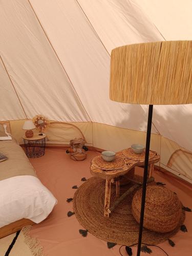 BoucéTente mongole " ô Rêves Atypiques"的带一张桌子和一张床的帐篷客房