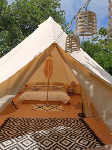 BoucéTente mongole " ô Rêves Atypiques"的白色帐篷,配有一张床和两把椅子