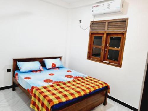 皮利亚恩达拉Hansi Villa的一间卧室设有一张床和一个窗口