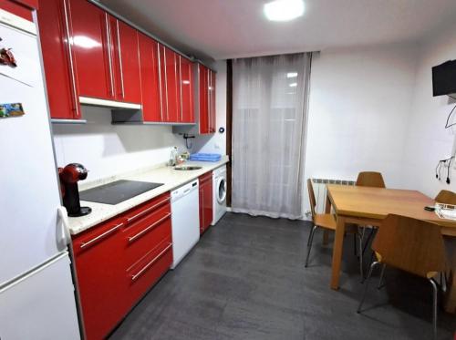 拉马莱斯德拉维克托里亚Casa bella alma的厨房配有红色橱柜和木桌