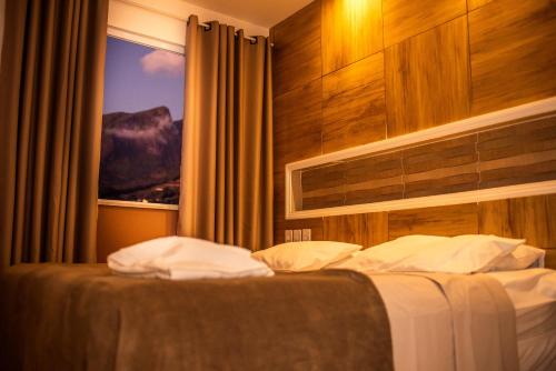 Caparaó VelhoPousada Encanto das Montanhas的酒店客房设有一张带窗户的床。
