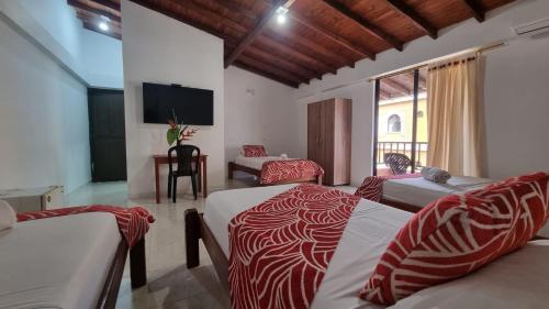 巴亚索拉诺Hotel Bahía Yubarta的一间卧室配有两张红色和白色床单