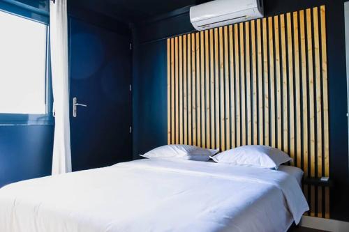 拉波塞雄Le Ôm : T2 sérénité et vue océan, proche 4 voies的卧室配有一张白色大床和木制床头板