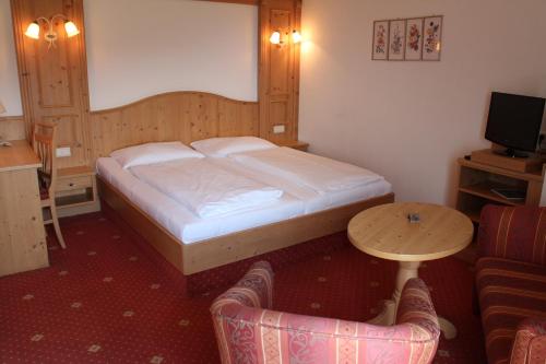 因斯布鲁克阿尔德兰瑟霍夫酒店的卧室配有1张床、1张桌子和1把椅子