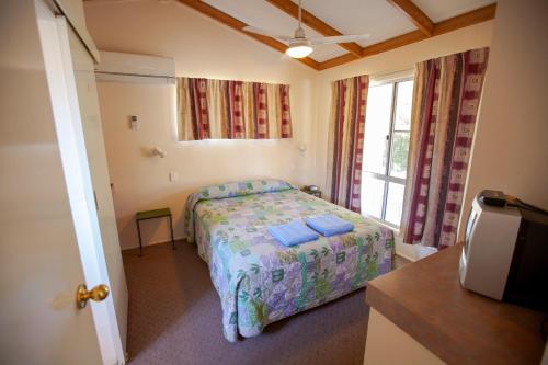 MitchellMitchell Motel & Cabin Park的一间卧室设有一张床和一个窗口