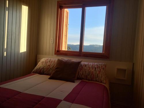 格拉玛多Gramado Família的一间卧室配有一张带窗户的床