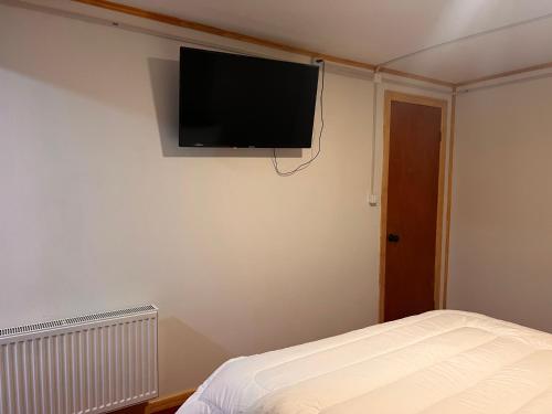 纳塔列斯港Hostal B&B Coastal Natales的卧室配有壁挂式平面电视。