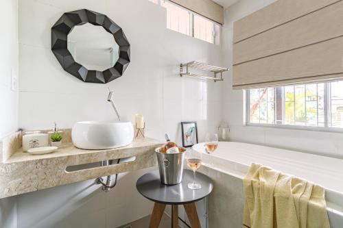 帕罗卡Pinheira Beach House com Jacuzzi的带浴缸、水槽和镜子的浴室