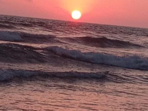 奥隆Estancias De Olon的海面上的日落,海浪在水中