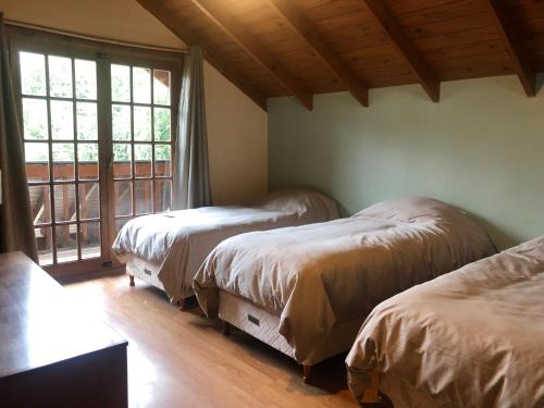 拉安戈斯图拉镇Cabaña patagónica的一间卧室设有两张床和大窗户