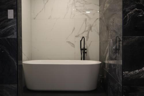 帕拉马里博Empire Villa Paramaribo Noord 1的黑白浴室设有白色浴缸。