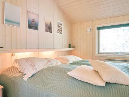 维斯特索马肯Holiday home Nexø X的一间卧室配有两张带枕头的床和窗户。