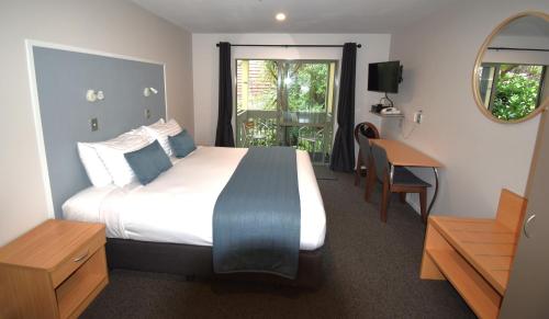 阿卡罗阿拉罗谢尔汽车旅馆的一间卧室配有一张床、一张书桌和一个窗户。