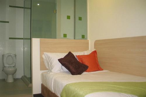 古晋Hotel 98的一间卧室配有一张带两个枕头的床和卫生间