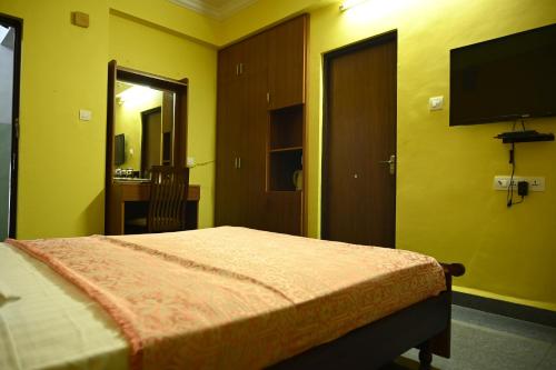 瓦尔恰Hotel Siesta De Goa的一间卧室配有一张床和一台平面电视