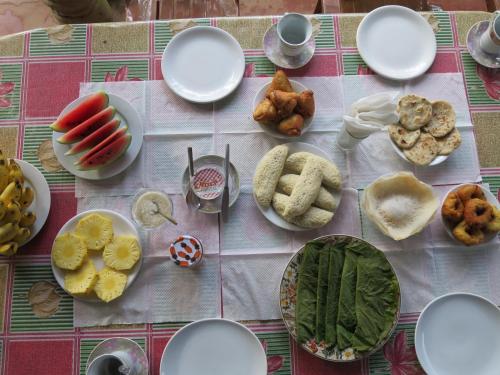 锡吉里亚Another World Hostel Sigiriya的餐桌上放有盘子的桌子