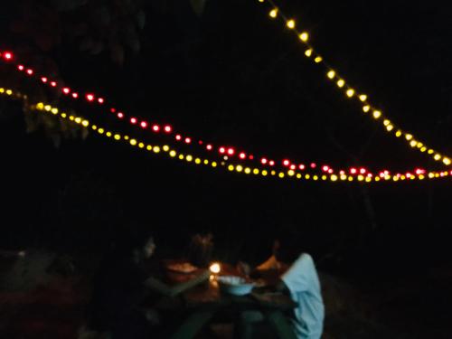 康提Little wood villa Doluwa的一群人坐在桌子上,灯火通明