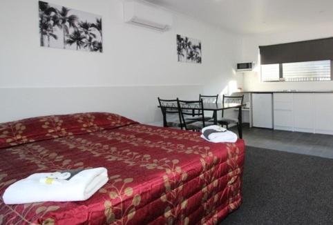 PahiatuaBrown Trout Motel的酒店客房配有红色的床和一张桌子