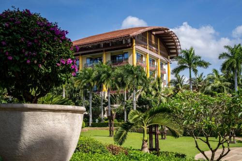三亚三亚亚龙湾瑞吉度假酒店（一山一海一庄园）的一座棕榈树的黄色建筑