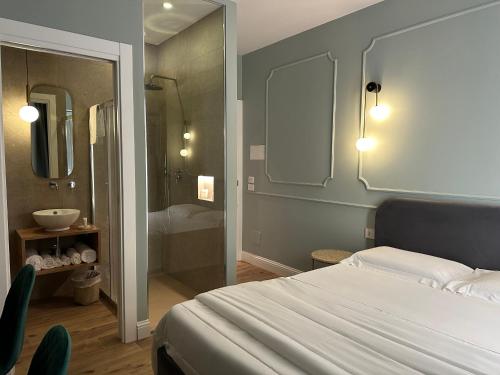 阿格里真托Krysos Luxury Rooms的一间卧室配有一张床,浴室设有淋浴。