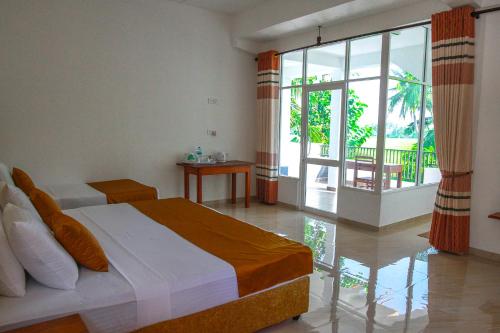 蒂瑟默哈拉默Hotel Nilketha Yala Tissamaharama的一间卧室设有一张床和一个大窗户