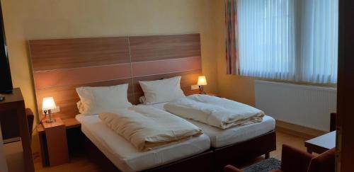 AylLinden's Pension-Restaurant的一间卧室配有一张大床和两个枕头