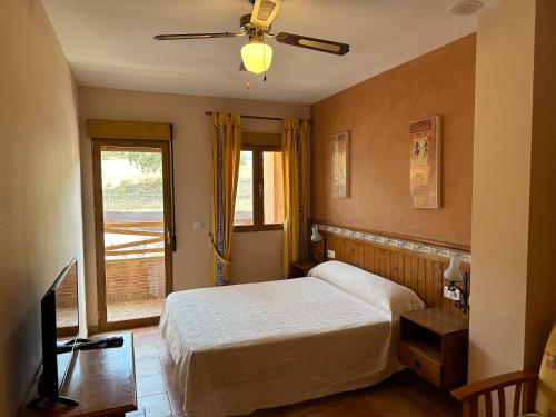 格拉纳达省阿拉马卡诺斯阿尔采瑟餐厅酒店 的一间卧室配有一张床和吊扇