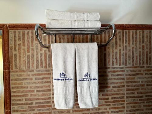 格拉纳达省阿拉马卡诺斯阿尔采瑟餐厅酒店 的浴室毛巾架上的一组毛巾