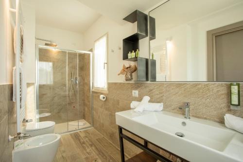 福洛尼卡Riva Toscana Golf Resort & SPA的一间带水槽、淋浴和卫生间的浴室