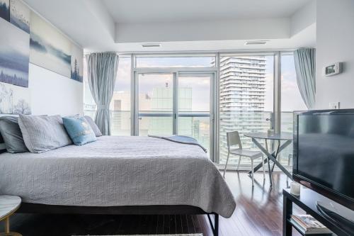 多伦多GLOBALSTAY Gorgeous Downtown Apartment的一间卧室配有一张床和一台平面电视