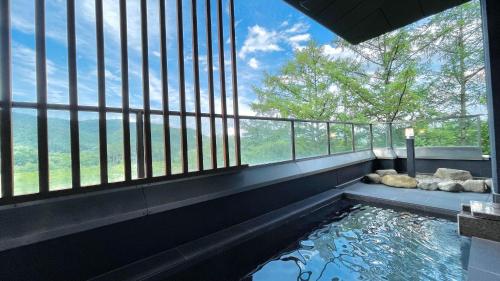 大町市Kurobe Sunvalley Hotel的一个带大窗户的房间的水池