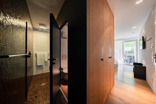 布列瑟农Soley Suites - adults only的一间带卫生间和玻璃门的浴室