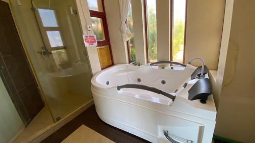 杉祖Lux Suites Shanzu Seabreeze Apartments的带淋浴的浴室配有白色浴缸。