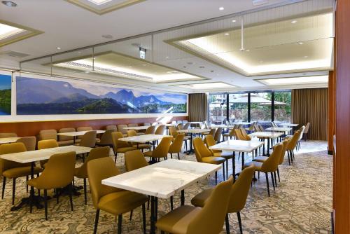 水里乡福容徕旅 水里的餐厅设有桌椅和大窗户。