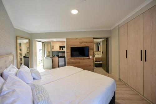 开普敦All Africa House (University Of Cape Town)的卧室配有一张白色大床和电视。