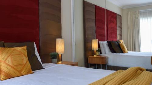 戴尔斯福特Lakeside Suite 3 - Lake View & Spa Bath的酒店客房设有两张床和窗户。